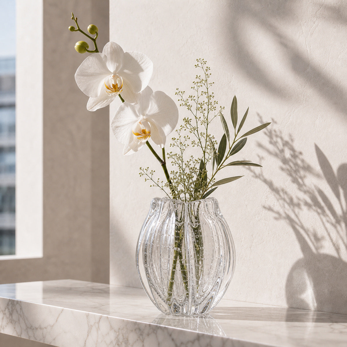 Onda Vase Calyx: Clear textured glass vase with white orchids and greenery on a marble shelf