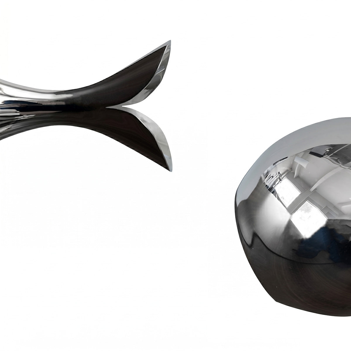 Vase details: Two metallic objects, one curved and one round, on a reflective surface.