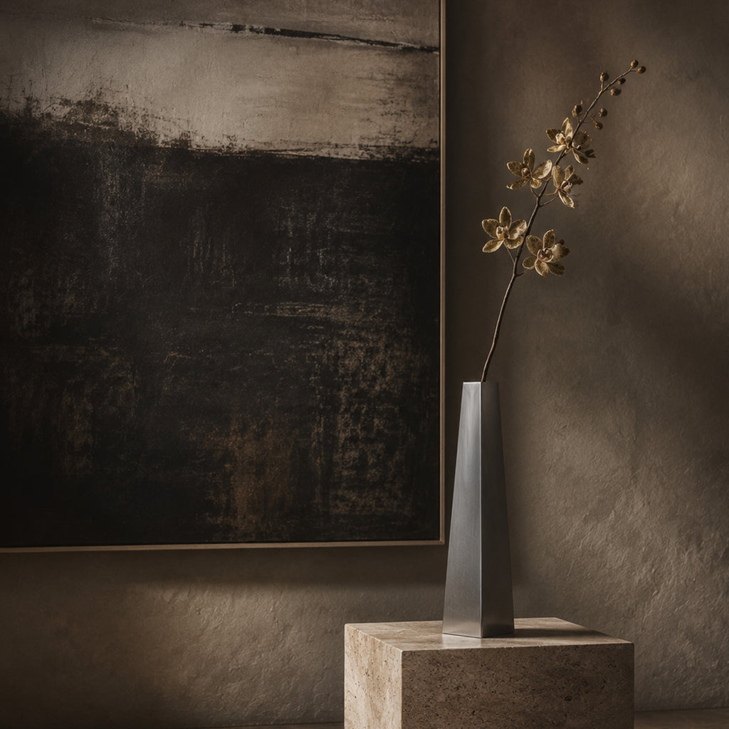 Decorative vase with flowers on a pedestal against a textured wall with abstract art.