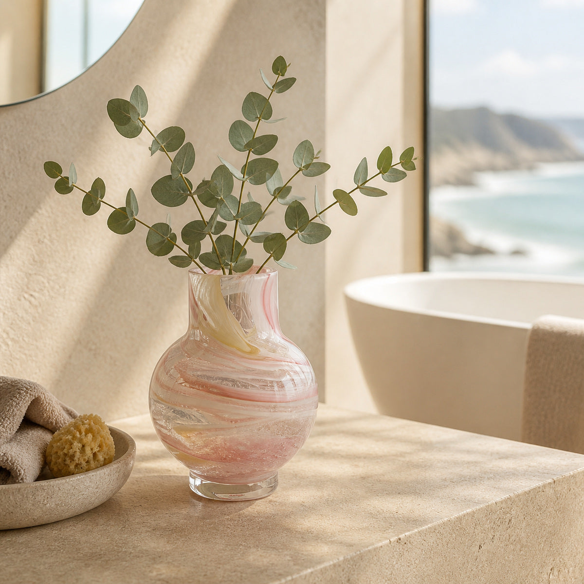 Decorative vase with green aus native branches on a stone surface near a bathtub and with water view.
