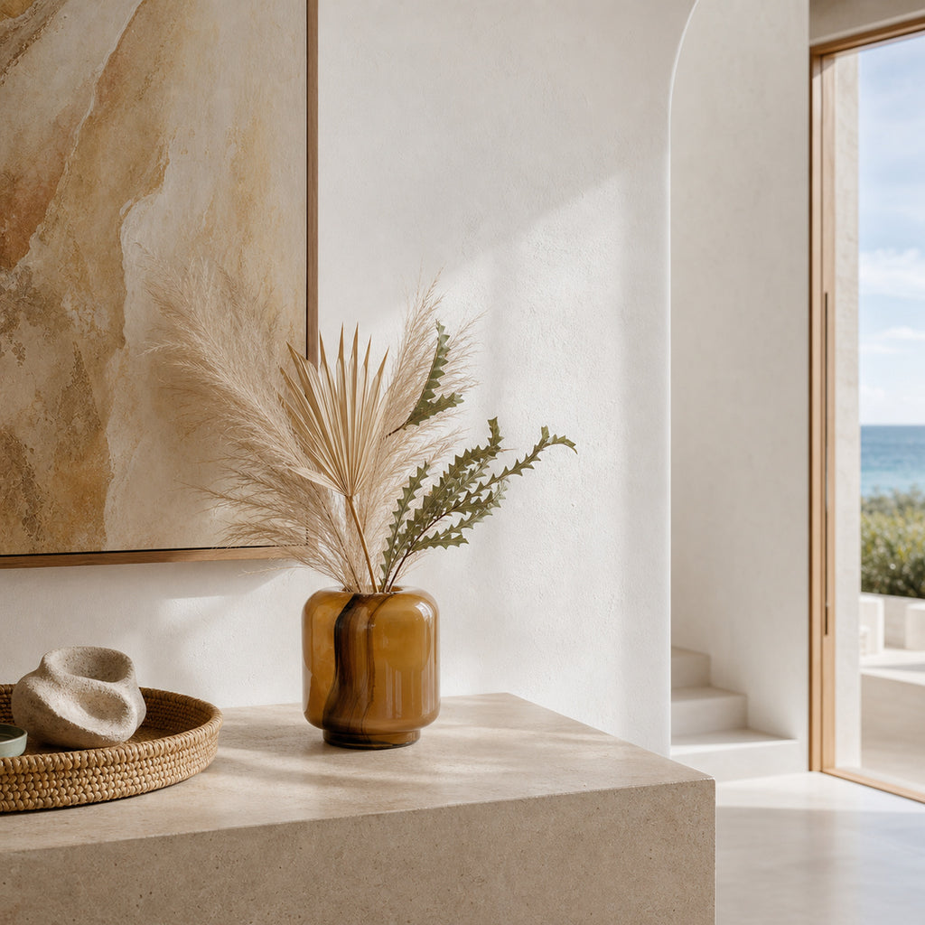 Onda Boleto caramel-brown glass vase styled with dried botanicals on a stone console in a coastal interior