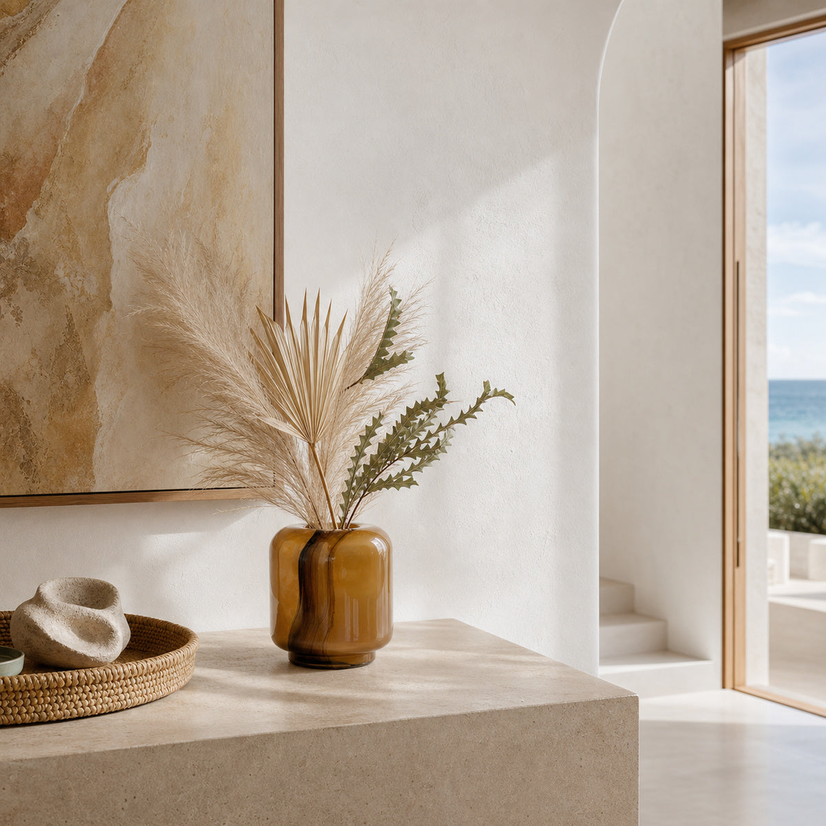 Onda Boleto caramel-brown glass vase styled with dried botanicals on a stone console in a coastal interior