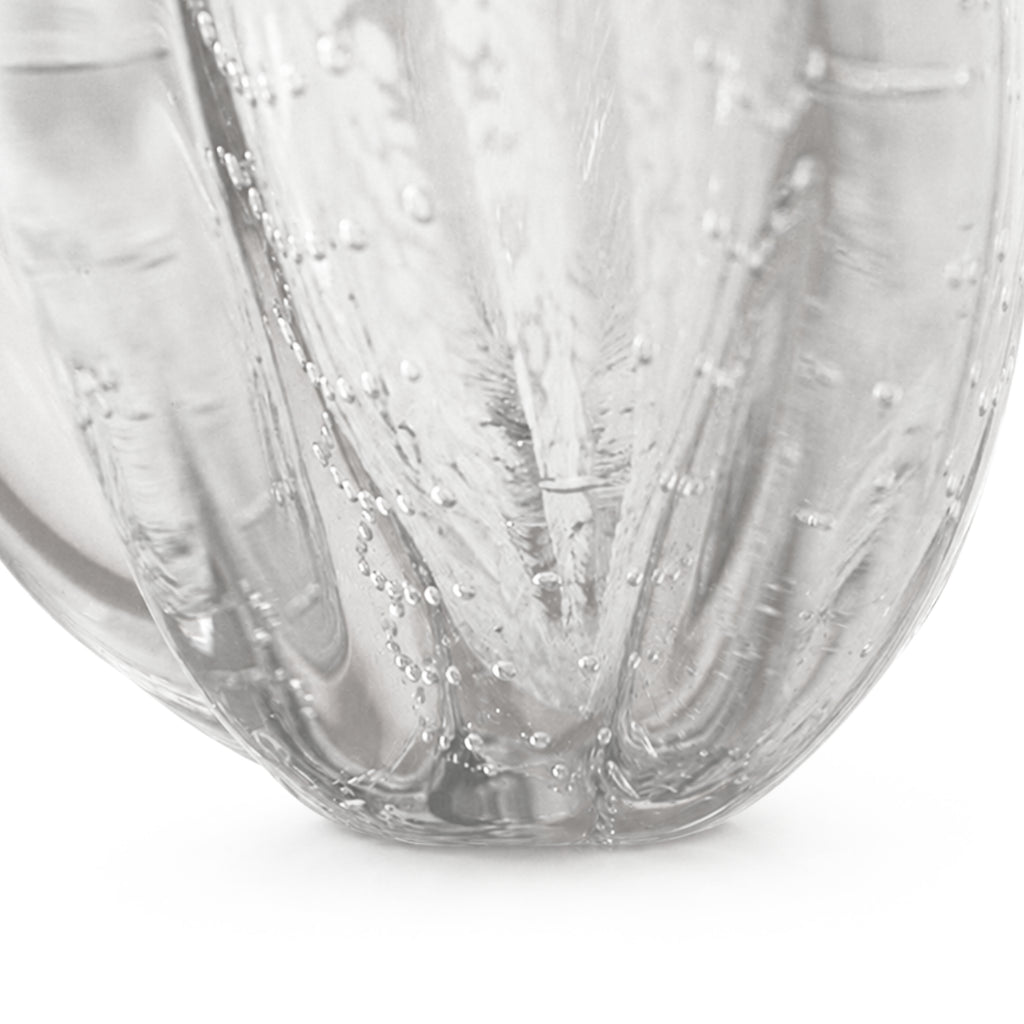 Close-up detail of the Onda Vase Calyx bottom base, showcasing the vertical ribbed texture and clear seeded bubble glass converging at the sturdy foundation, isolated on a white background.
