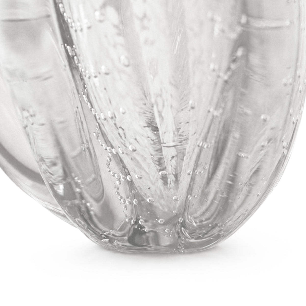 Close-up detail of the Onda Vase Calyx bottom base, showcasing the vertical ribbed texture and clear seeded bubble glass converging at the sturdy foundation, isolated on a white background.