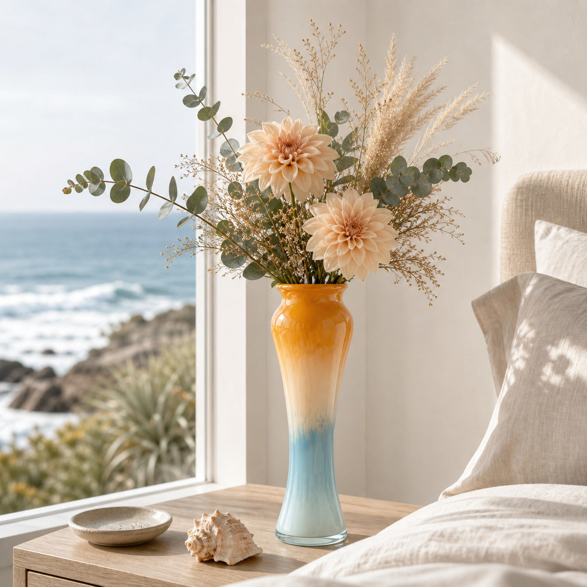 Gradient Glass Vase - Onda Vase Solis displaying peach dahlias and pampas grass on a coastal bedroom nightstand with an ocean view.